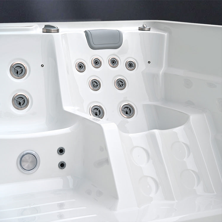 Close-up of a white hot tub with control buttons on a dark background