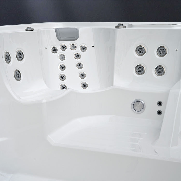 Close-up of a white hot tub with multiple jets on a dark background